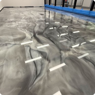 Metallic marbled epoxy floor finish with a high-gloss swirl pattern